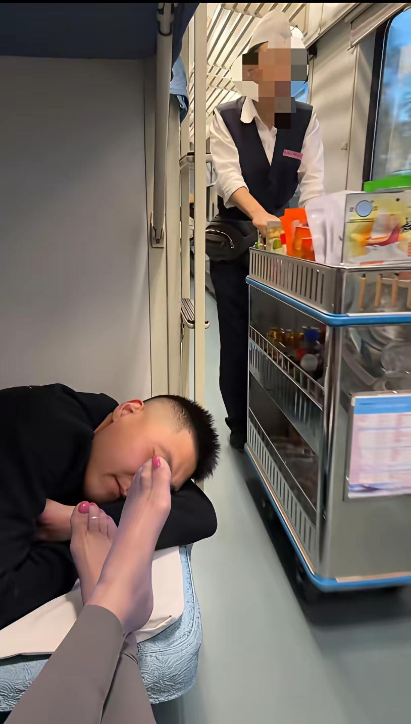 对面应该是她老公，不然她怎么能这么放肆，把脚放到人家的头前，也许是趁人家睡得正香