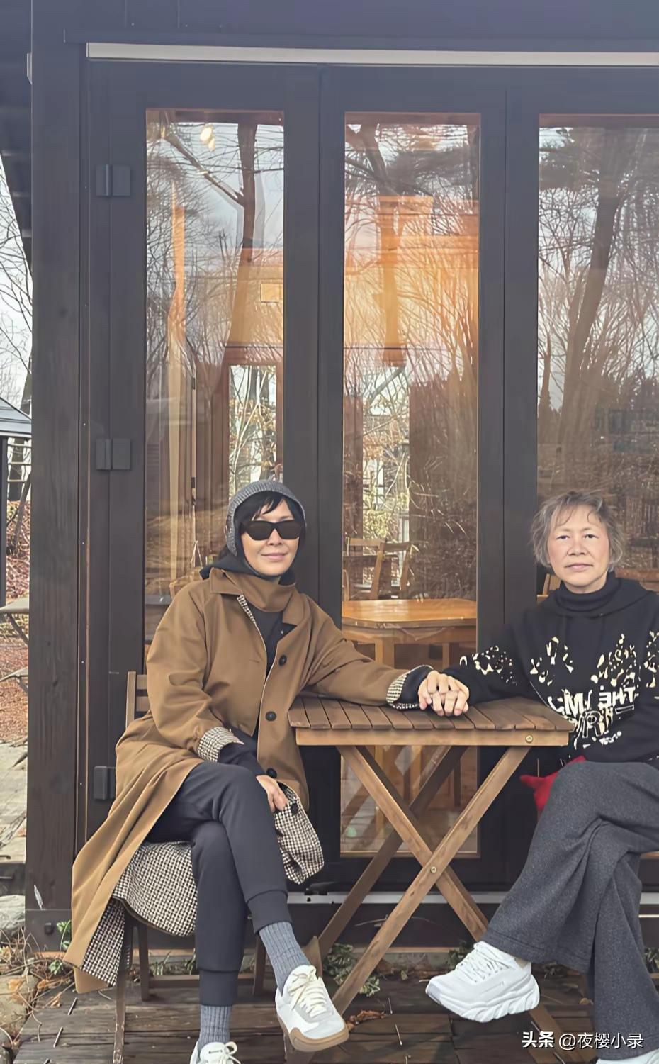 刘嘉玲分享和家人去国外度假，母女俩人坐在木屋前握着手温馨有爱。镜头前60岁的刘嘉