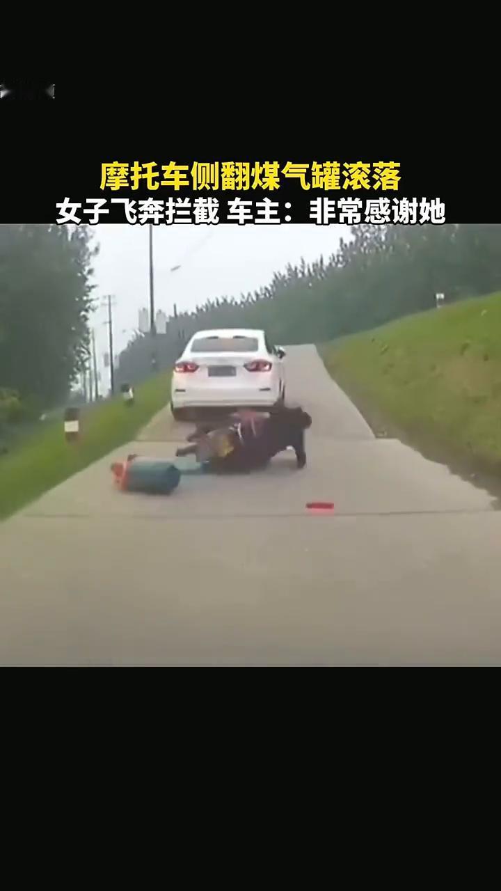 摩托车侧翻煤气罐滚落，女子飞奔拦截车主：非常感谢她。
事情发生得有点突然，煤气罐