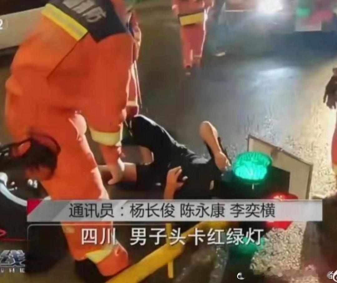 男子骑车玩手机致脑袋卡进红绿灯行车不规范，亲人两行泪。骑车玩手机，导致自己头被卡