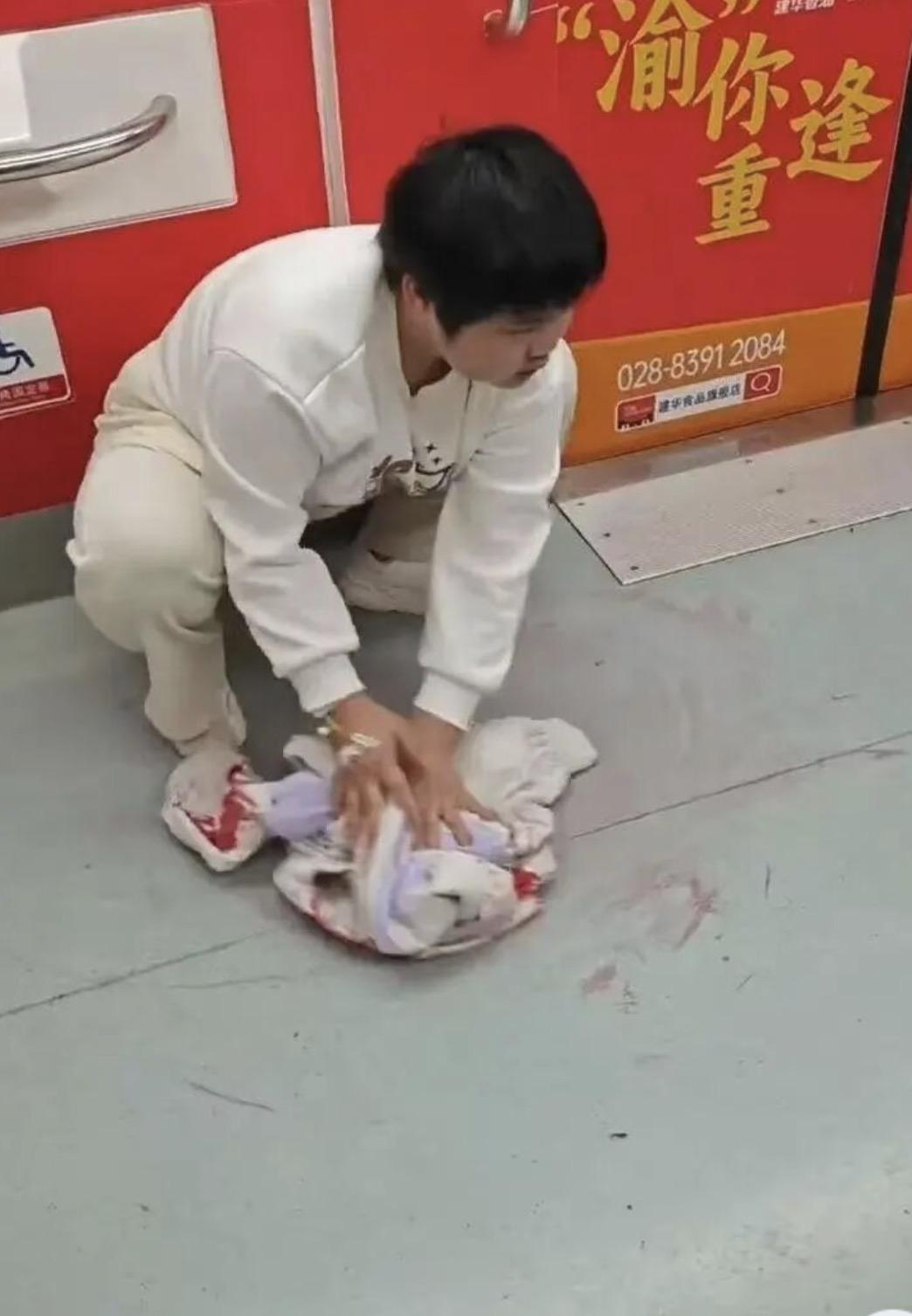 3月23号，重庆地铁1号线，一个瘦得脱相的女孩蹲在地上，拿自己最喜欢的白色外套擦