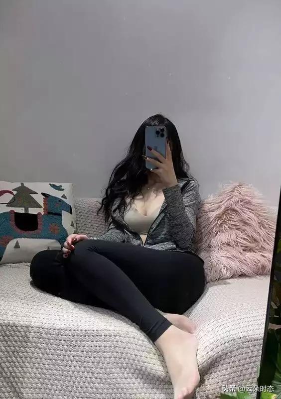 慵懒窝在沙发里，长发垂落间藏着几分随性。浅灰外套松垮搭在肩头，勾勒出恰到好处的曲