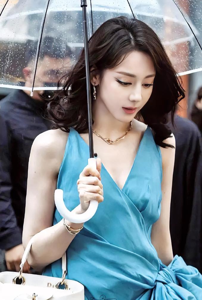 刷到迪丽热巴的这张照片，瞬间被惊艳到。
她在南京雨中撑伞的美照火爆全网，狠狠拉高