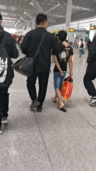这是什么情况？
网友在火车上拍到一名身材瘦小戴着手铐的男子在三名便衣警察的押解下