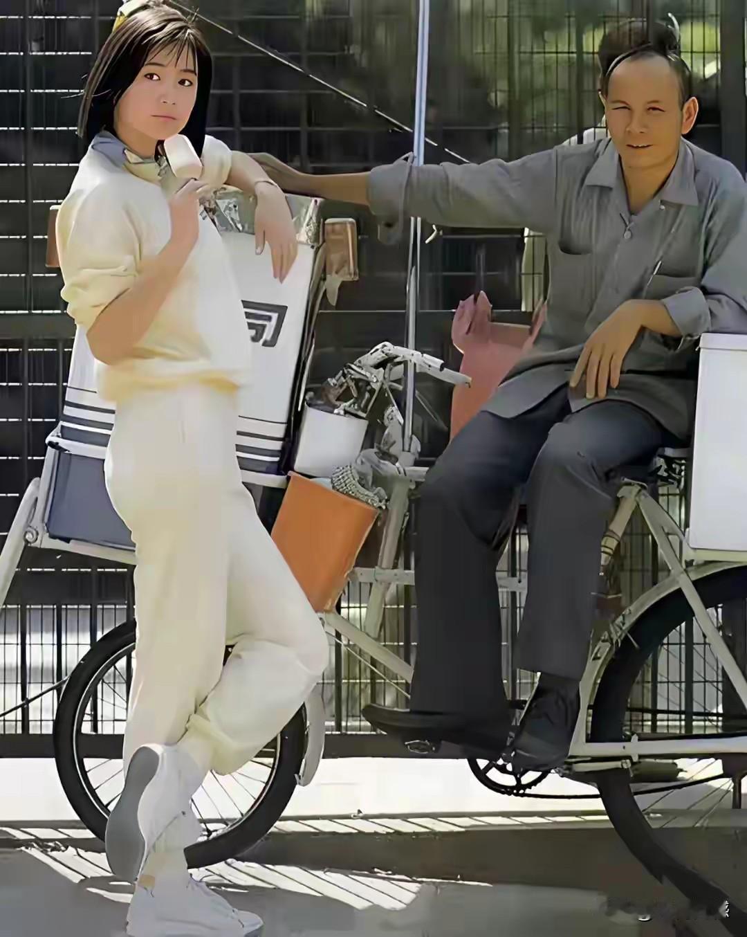 林青霞站在街头吃雪糕，这应该不是剧照，感觉就是随手拍下来的照片，这张照片照的非常