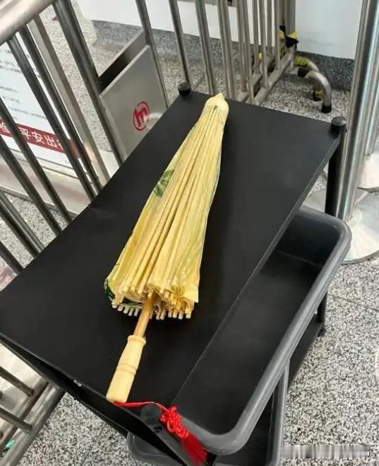 在浙江杭州，一女子旅游时在景区买了把油纸伞，准备乘地铁去机场，却在安检处被告知伞