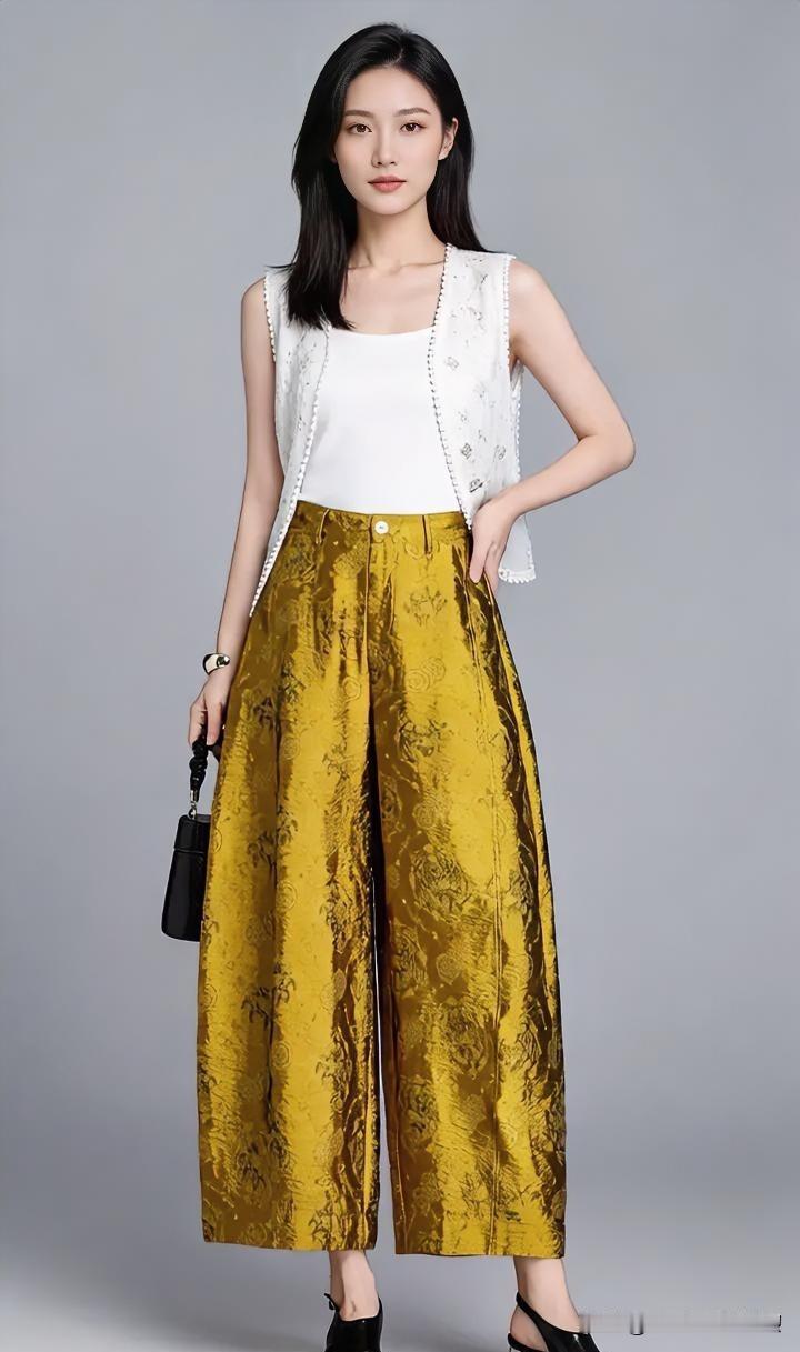 金缎阔腿裤流转着华美光泽，白色马甲轻盈点缀。她闲庭信步，于极简背景中自成风景，将