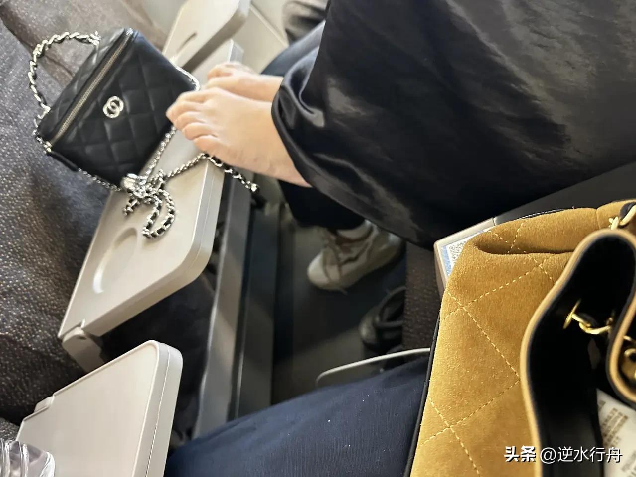 遇到这种情况你会怎么办？背着名牌包包，没想到上车就把双脚搭到小桌板上，这素质真是