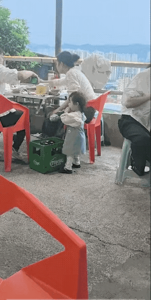家人带着宝宝吃来吃饭，大人在桌上倒酒，吃着美食，宝宝见没人管我，自己拿着酒瓶喝了