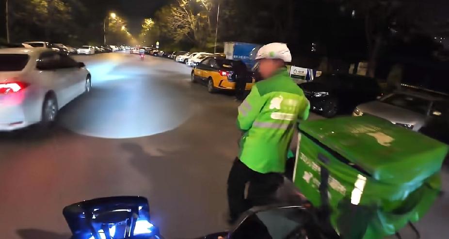 深夜时分，一名外卖小哥竟然推着电动车，在马路上小跑着，路过的陌生男子，一个举动，