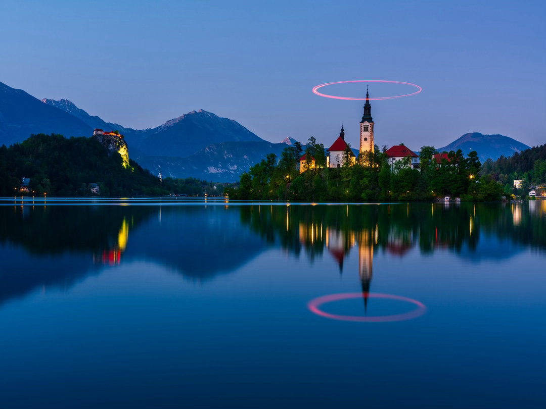 在布莱德湖的蓝调时刻，用无人机的光绘轨迹，为百年教堂加冕。让科技的“红”与大自然