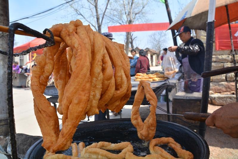 看短视频，河南某农村一对年轻夫妇，每天在家里炸一车油条糖糕，小伙子骑着电动三轮车