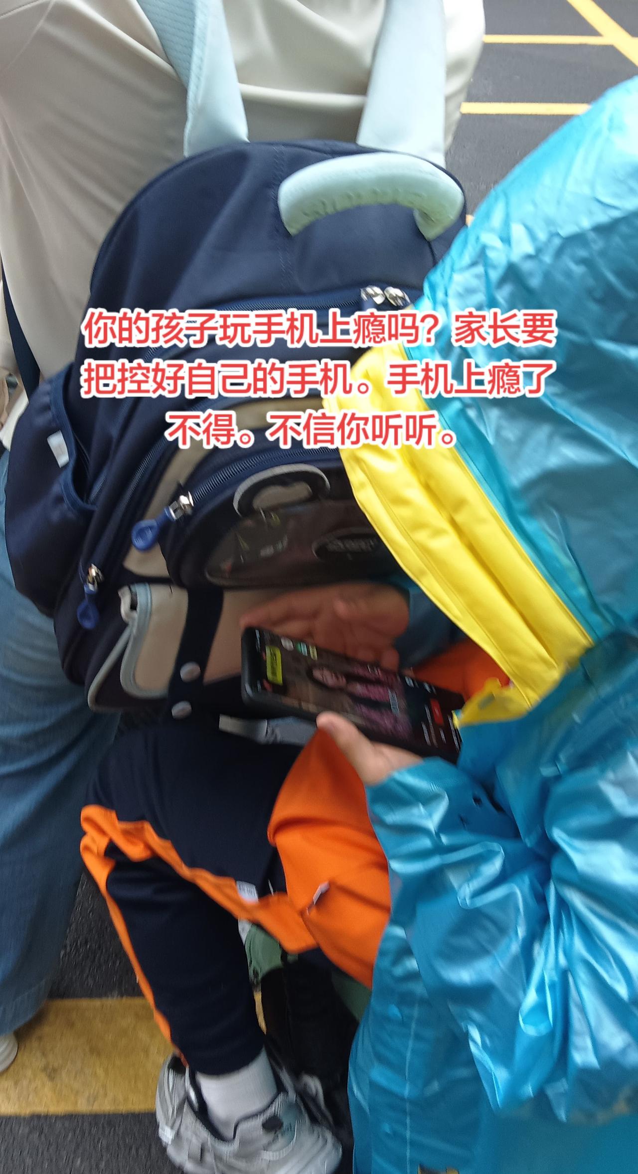街头随拍，你的孩子玩手机上瘾吗？看看这个小学生，下雨天坐在妈妈电动车后边在刷视频