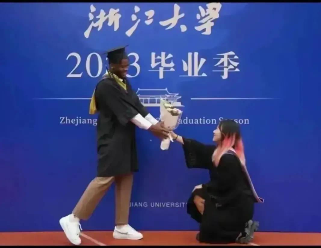 女孩单膝跪地给黑人留学生送花。是不是毕业了，黑人留学生要回国了，女孩单膝跪地送花
