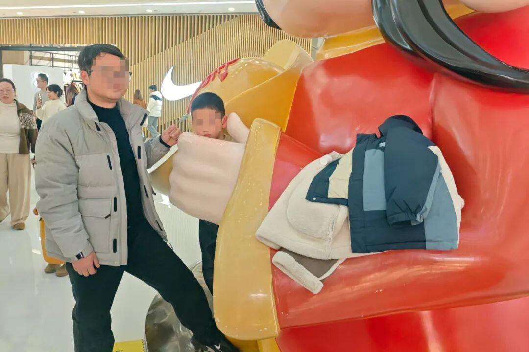 义乌商场惊现“招财童子”！男童头卡财神雕塑怀中被“强行留财”，消防员暖心救援现场