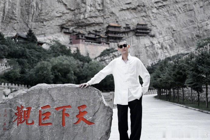 张翰晒游客照张翰游客照张翰晒游客照，在古建筑前双手合十，在自然胜景中自在站立，白
