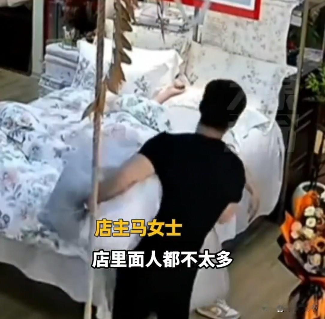 河南郑州一家纺店，00后员工理完货累得在展示床上睡着了。老板娘走过来，旁边员工以