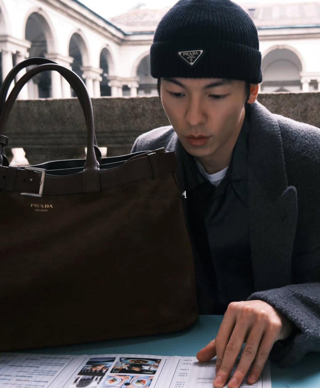 许光汉米兰时装周街头随拍｜Prada双套穿搭灰色绒面大衣搭配毛线帽，肩背Re-N