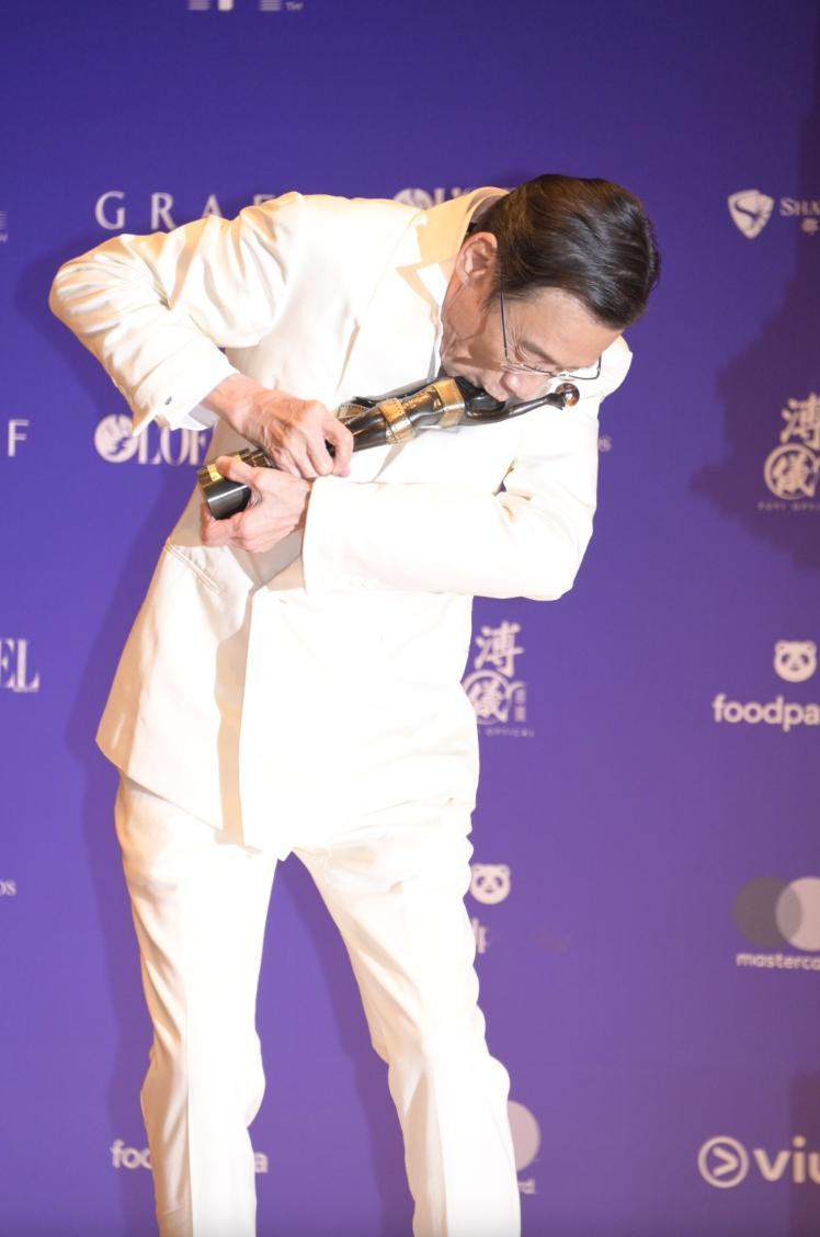 梁家辉亲吻奖杯🏆。 