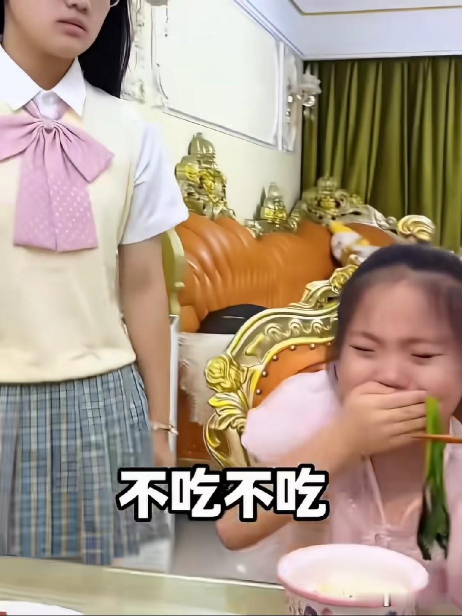 一小女孩手捂着口，死活不吃爸爸夹来的蔬菜，爸爸怎么哄都不行。姐姐看见了，径直走过
