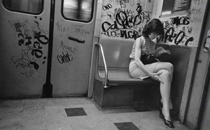 1981年，美国纽约地铁上，一位打扮时髦、低头看书的年轻华裔女性，与车厢的环境格