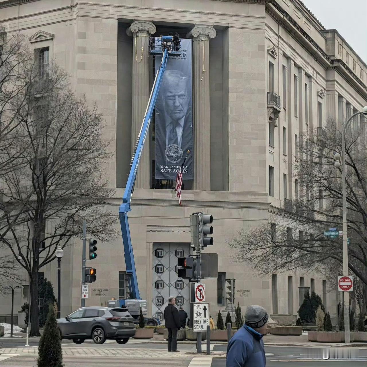 美国司法部大楼外赫然悬挂特朗普巨幅肖像，并写着「让美国再次安全」，这一举动迅速引