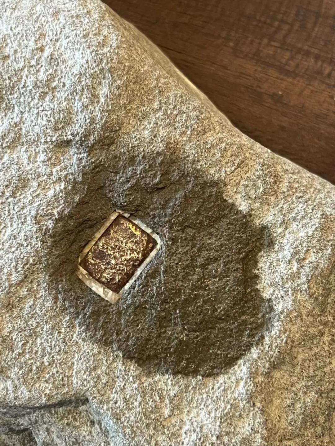 徒步时山里捡到一块奇特的石头，上面有一块方形的金属块，有懂是什么的吗？有人说是黄