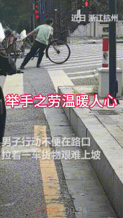 人间处处有温暖，生活充满正能量！

十字路口一辆三轮车正在艰难地爬坡，大家都在等