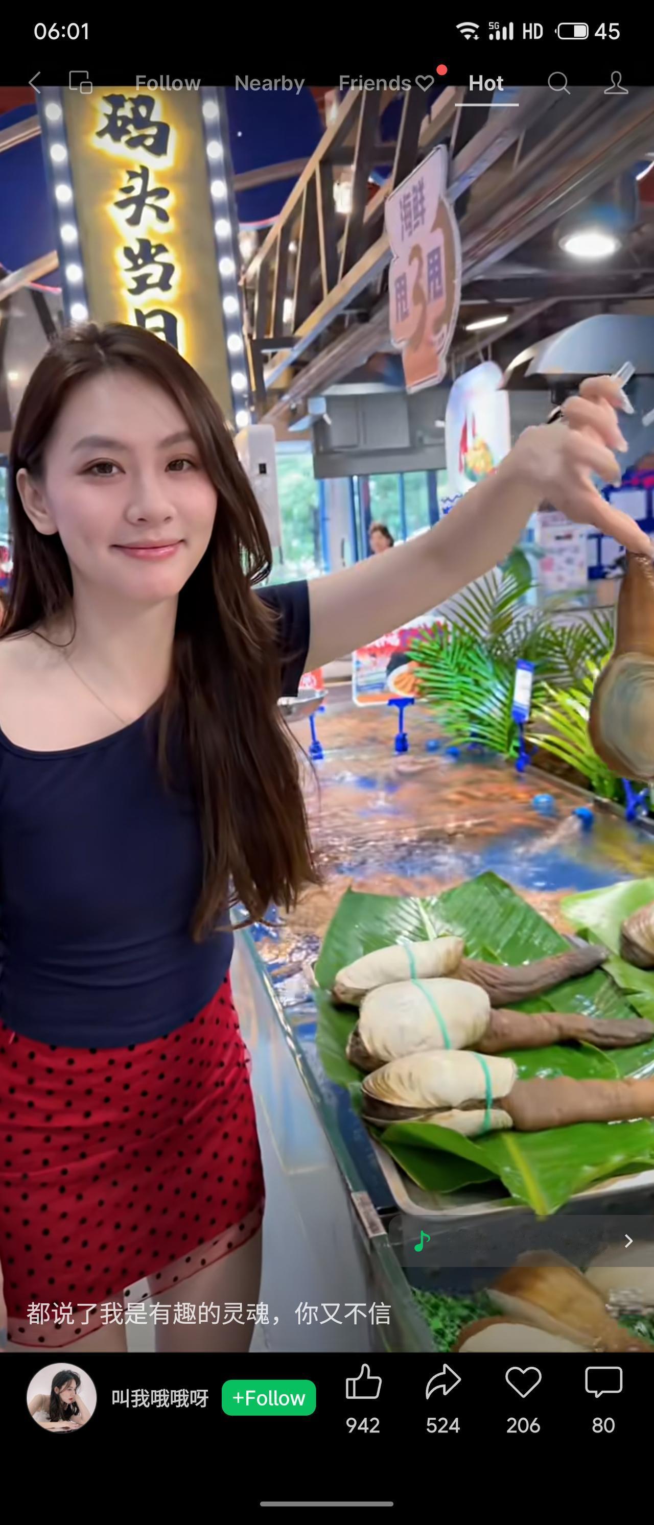 海鲜档口氛围鲜活热闹，长发女生穿搭亮眼，藏青上衣搭配红底波点短裙。她俏皮摆弄着肥