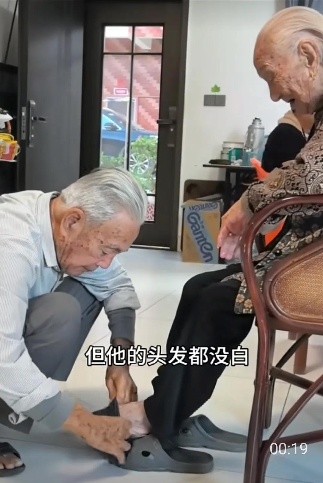 这个老人85岁了，还能蹲下来给老母亲穿袜子，很了不起呀，身体真好。