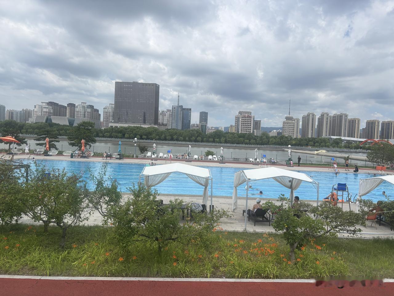 藏在汾河岸边的露天泳池，是太原人消解暑气的宝藏去处。澄澈蓝池铺展在汾水之畔，白纱