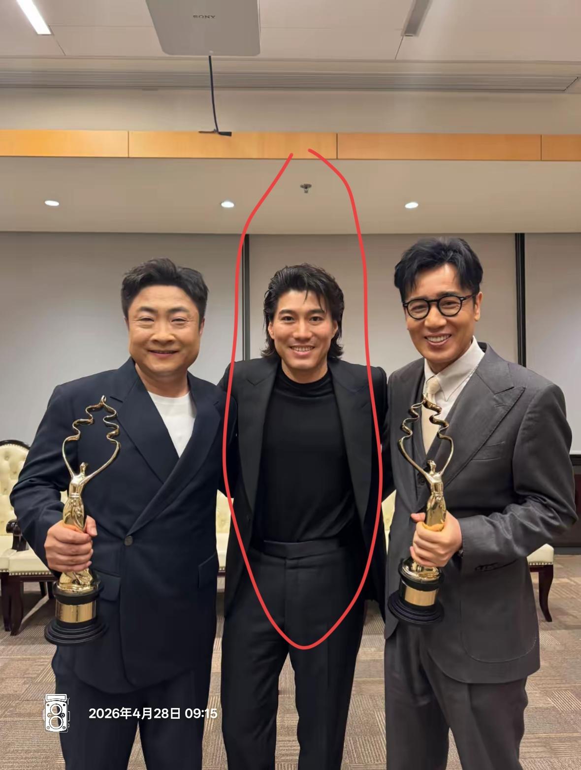 三位男士在室内合影，手持奖杯。说实话，中间这位 ，真不认识[捂脸]他有什么作品，