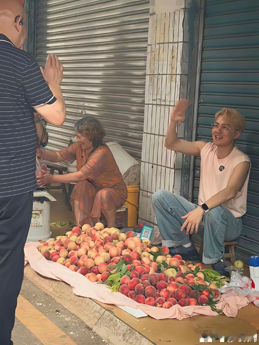 吴克群，算是找到不一样的赛道，开始做一些接地气的事情。

图片中，他进行吆喝卖桃
