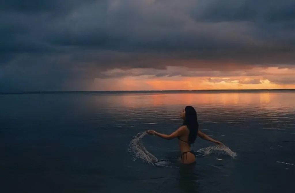 阳光洒满金色沙滩，海浪轻拍着岸边，一幅动人心魄的画面中，赵奕欢身着泳装，身姿曼妙