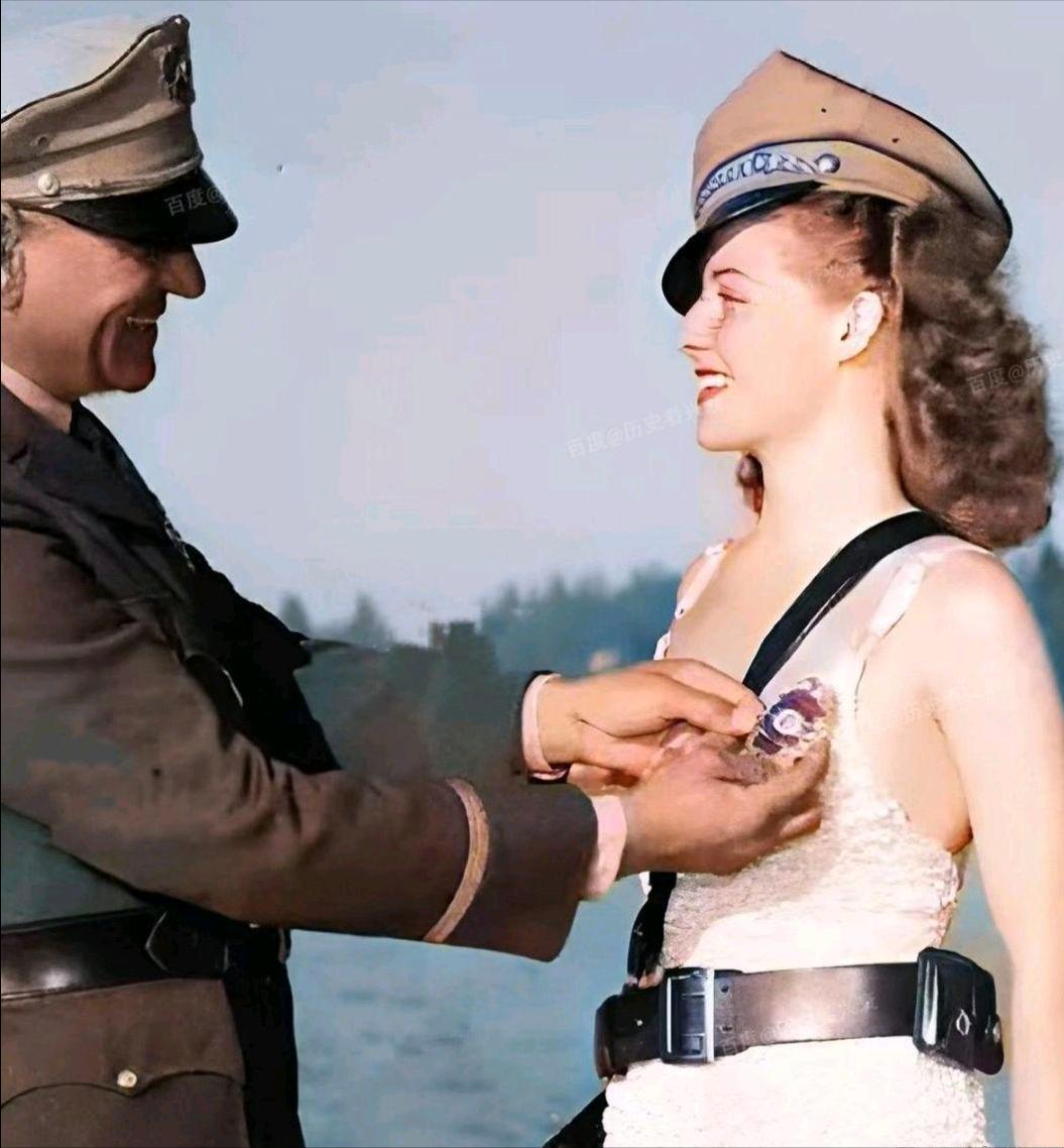 上世纪30年代，一个满面笑容的美国军官，正在给一个笑容满面的女下属佩戴勋章。

