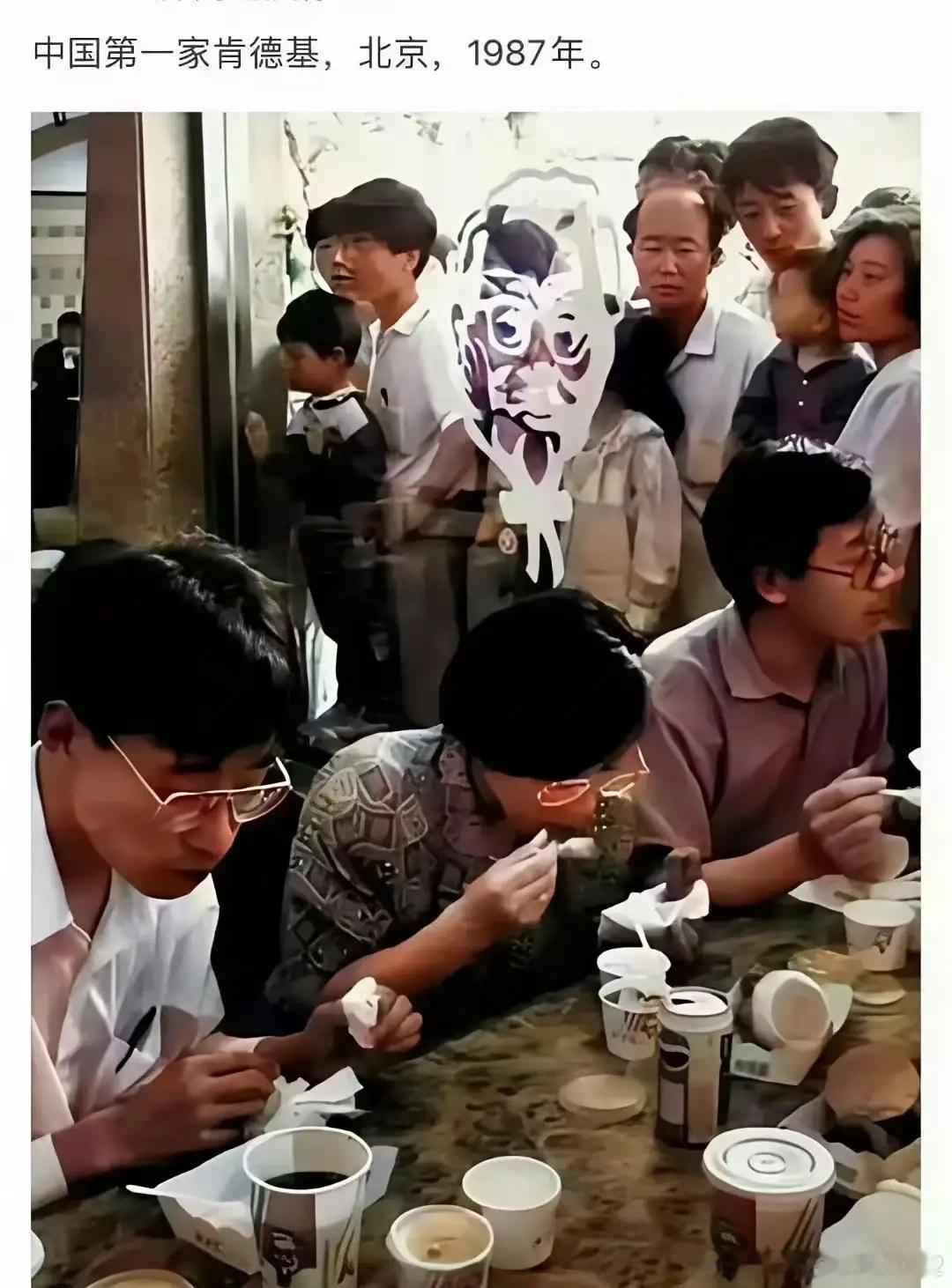 1987年，北京中国第一家肯德基开业。店里顾客在吃，外面的人透过玻璃在好奇地围观