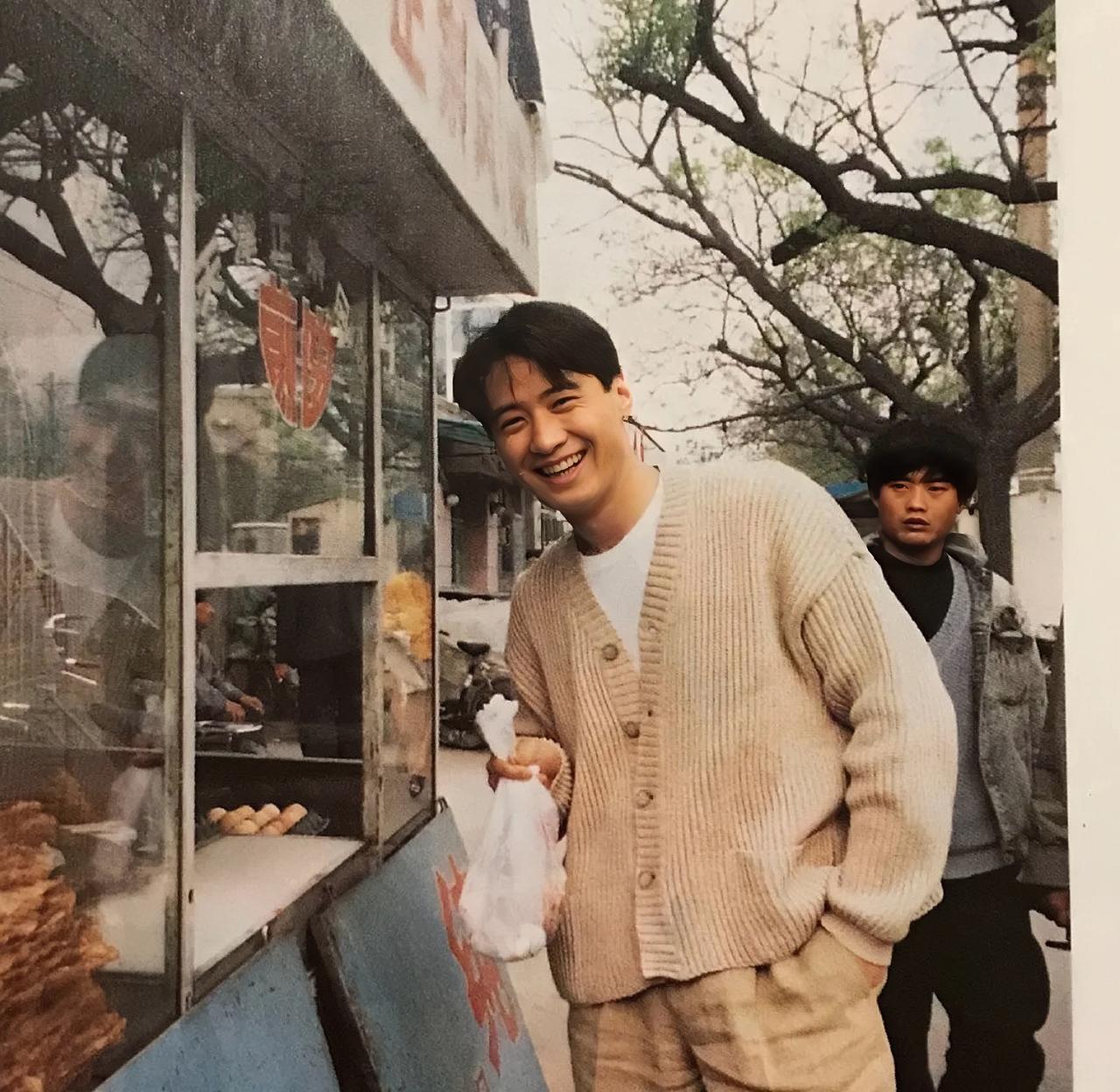 黎明的旧照，三十年前，他在北京街头吃煎饼的画面。

那个时候的黎明，年轻帅气，白