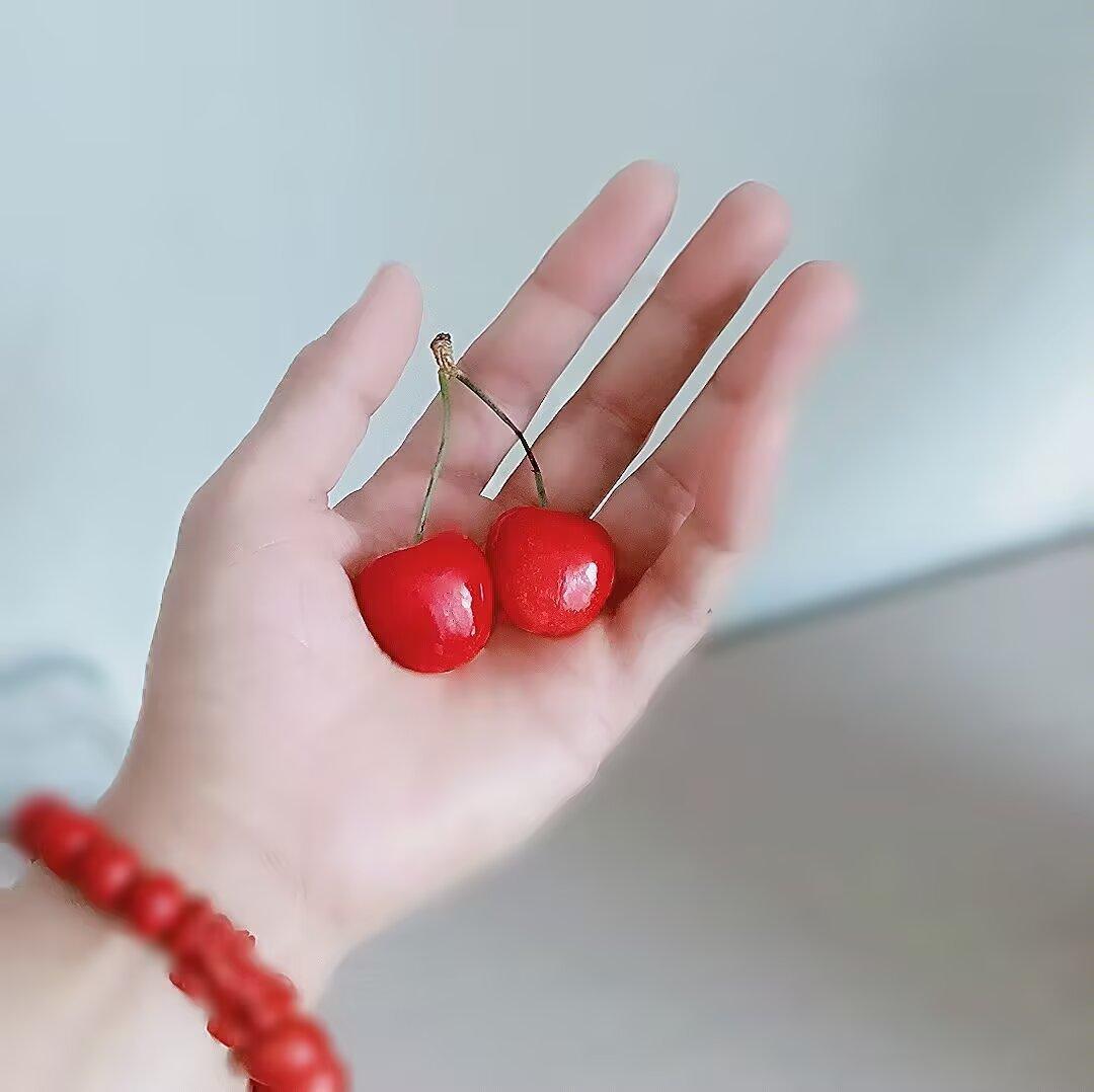 上联：玉手托鲜，两点殷红凝露美
下联：红珠绕腕，一痕丹赤衬肤娇