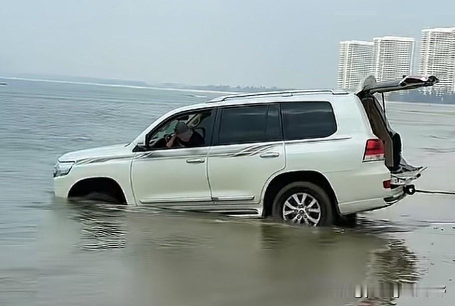 湛江吴川的海滩边，又出了豪车被困海滩上被海水浸泡的结果。图中的丰田陆地巡洋舰，车