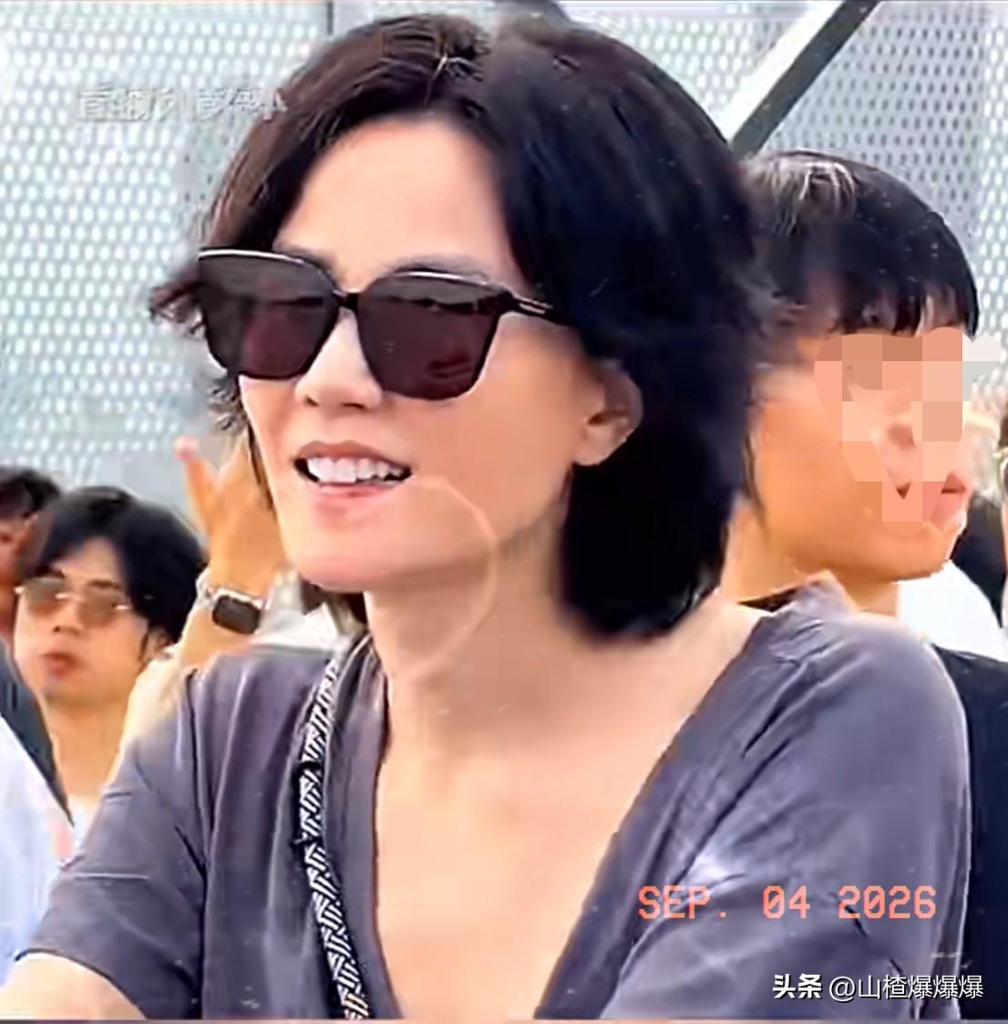 王菲素颜出镜，
岁月痕迹明显却依旧美丽大方，
打扮随意却笑容满面。

王菲出现在