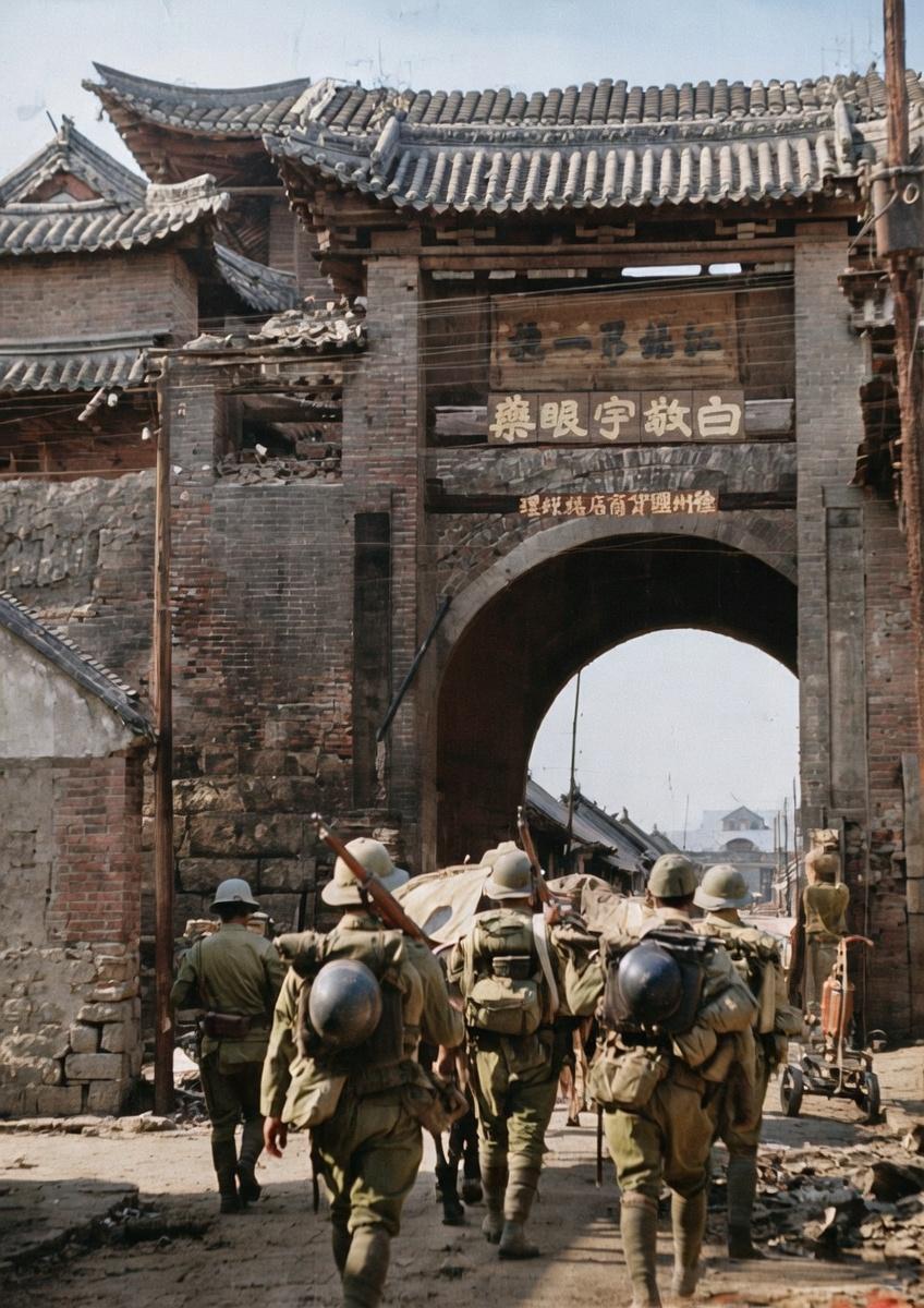1938年5月19日，徐州沦陷，一群全副武装的侵华日军正列队通过徐州古城门。城门