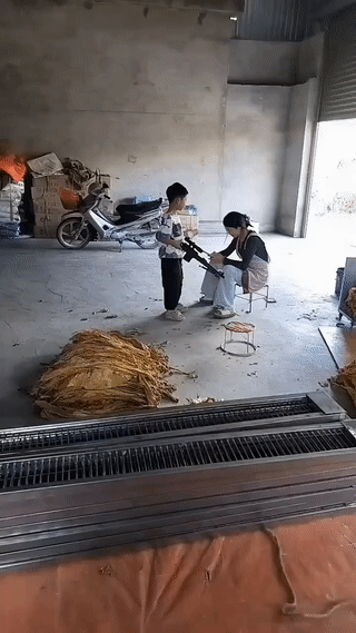儿子把一个饮料罐放到妈妈头上靶子？
而后抬手举枪射击，直接击落。
虽然枪法很准，