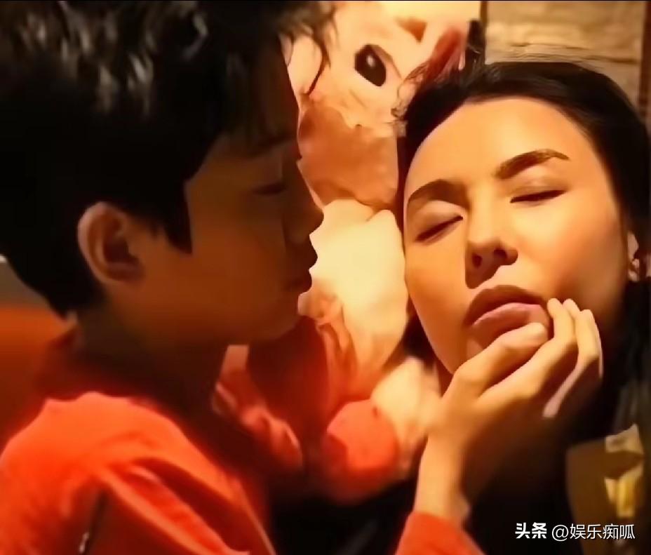 张柏芝在沙发上睡着了，嘴微微张着。她大儿子走过来，没叫醒她，伸手轻轻托住她下巴，