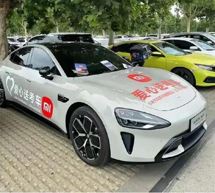 小米SU7被喷了....因为贴上了爱心送考车的字样，但却在高考期间一直停在车展的