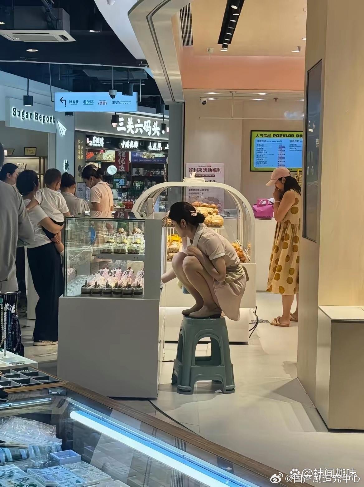 她为什么要这样蹲着摆东西 