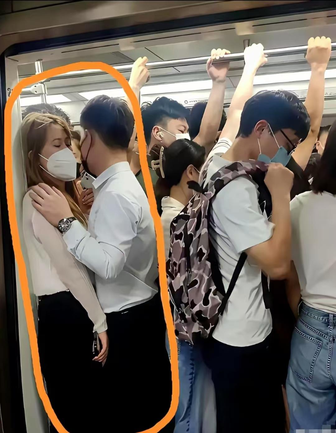 挤得满满当当的车厢里，两人紧紧贴在一起，男生手搭在女生肩上。
大家猜猜，他们是情