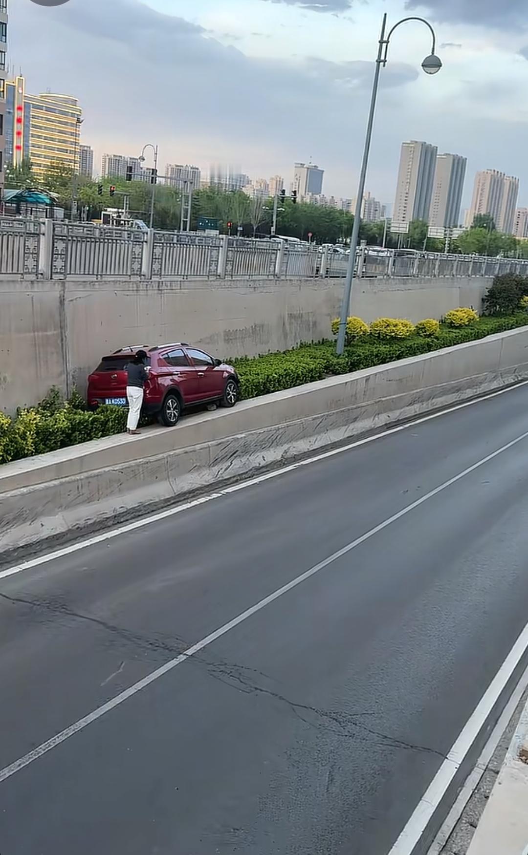 有人知道这位女司机是怎样把车开上绿化带的，最主要是车子完好无损，绿化带离公路一米