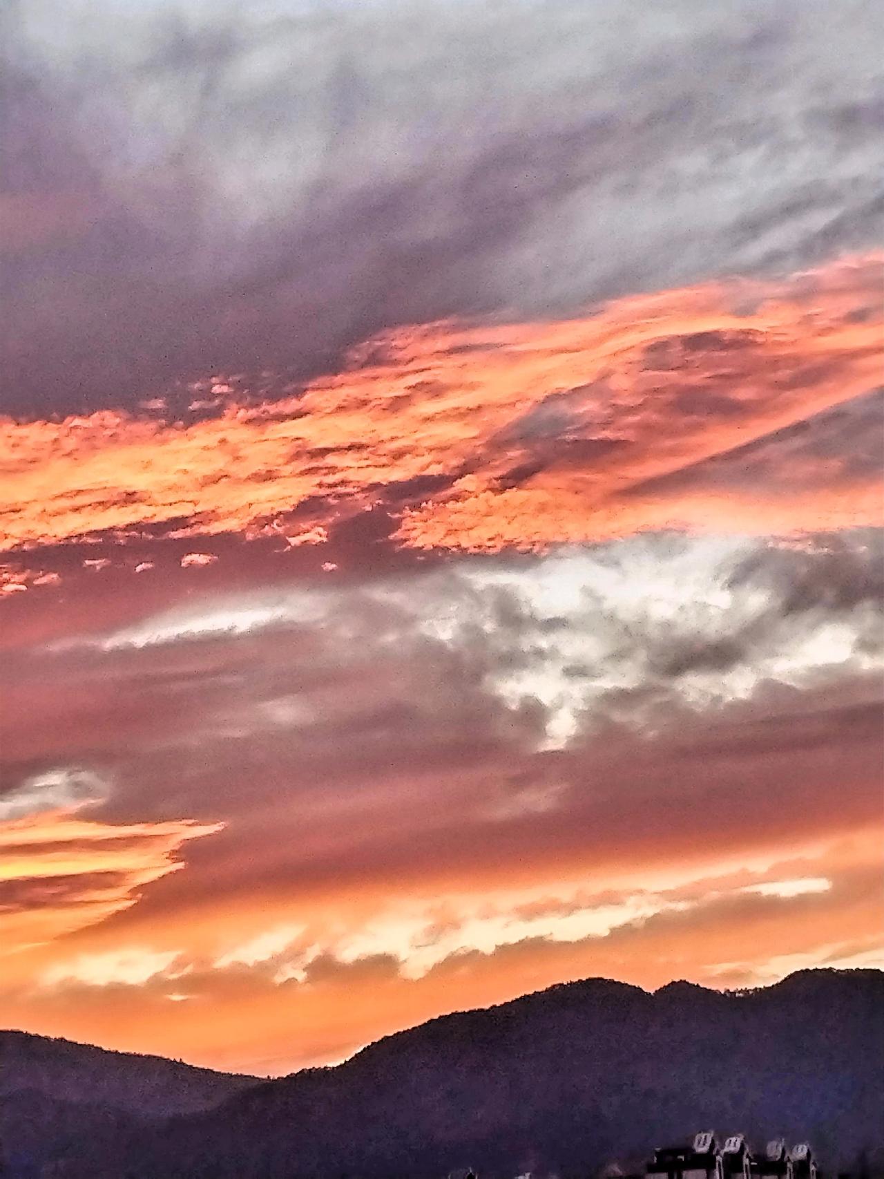 日落时分，云海翻滚，山峦静谧，美不胜收。此时，夕阳宛如一颗被烧红的巨大宝石，缓缓