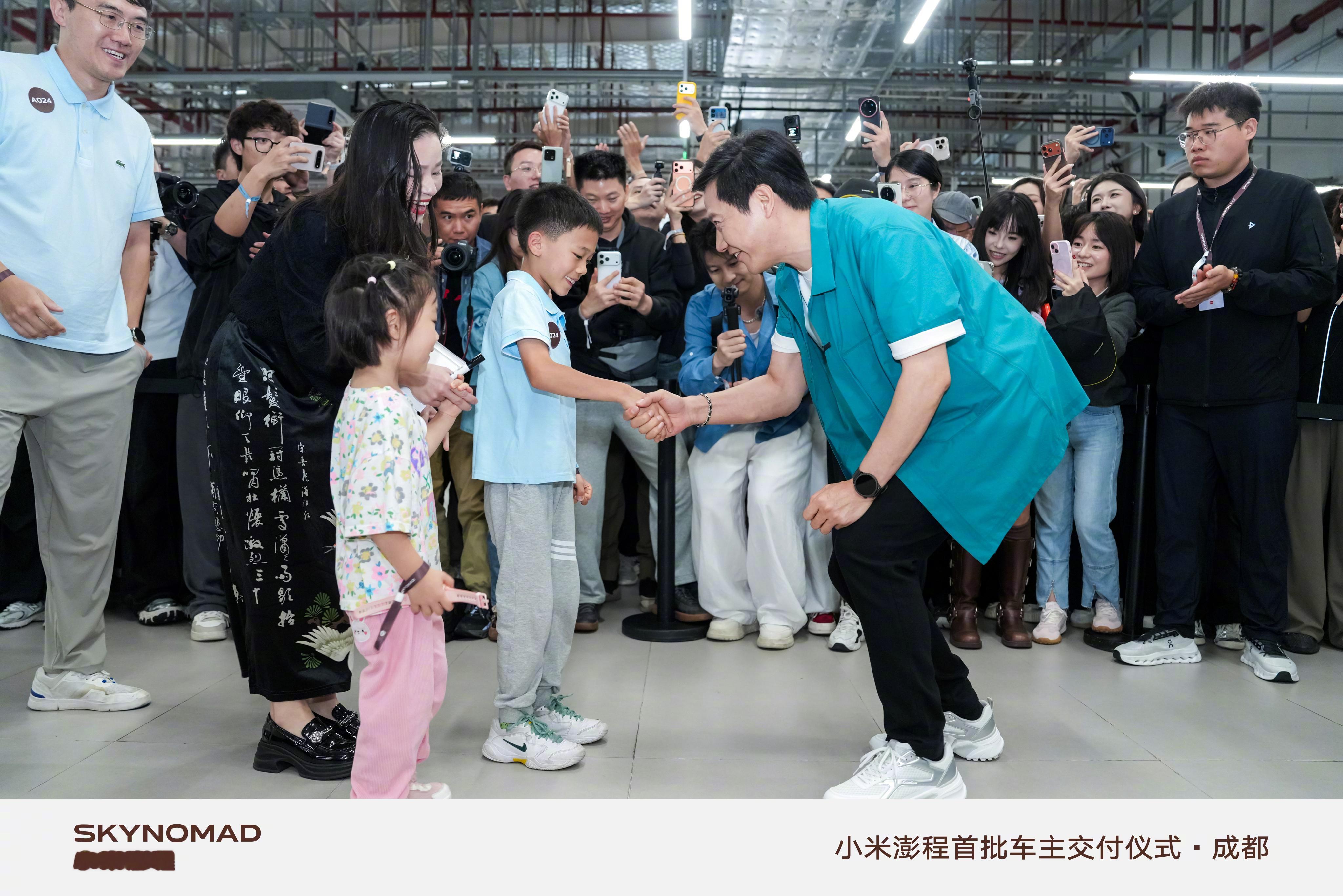 澎程车主拿初代小米手机与雷军合影 今天轮到成都的首批澎程车主享受雷总开门待遇了，