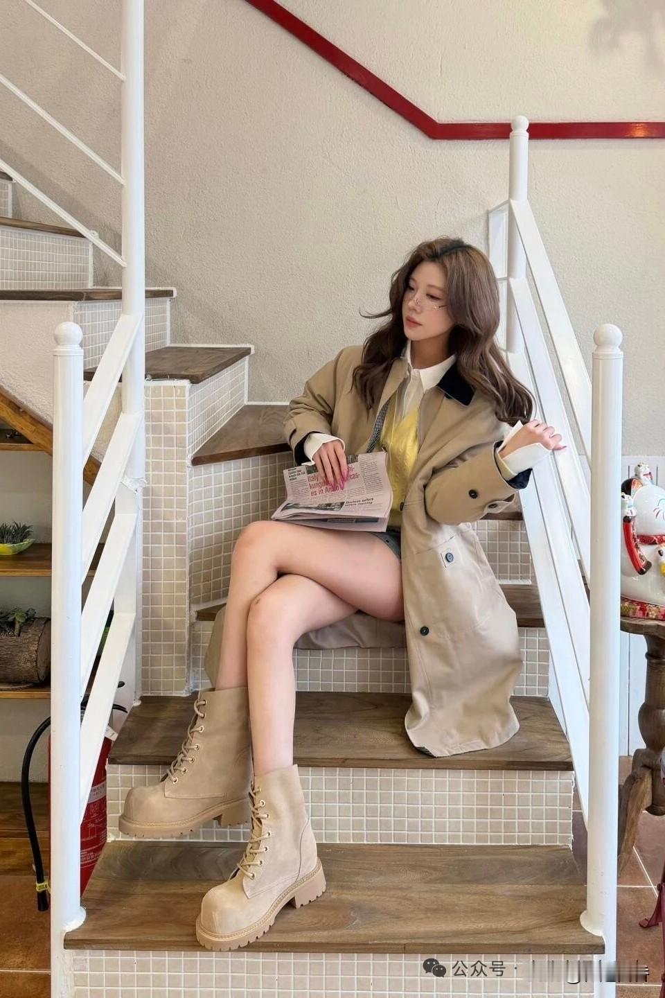 米色风衣搭配短靴，优雅又时髦，坐在楼梯上阅读，享受宁静时光。